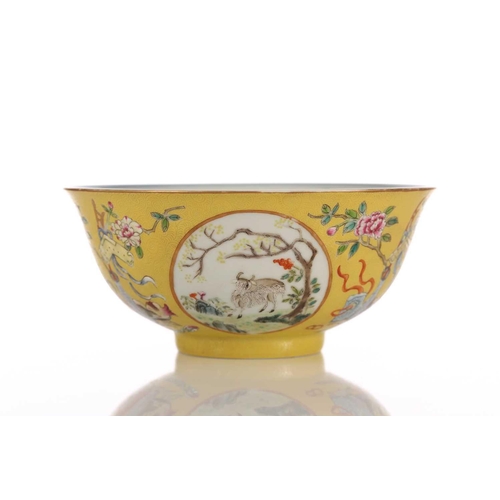 170 - A Chinese yellow ground bowl, 20th century, painted with medallions of goats by blossoming trees wit... 