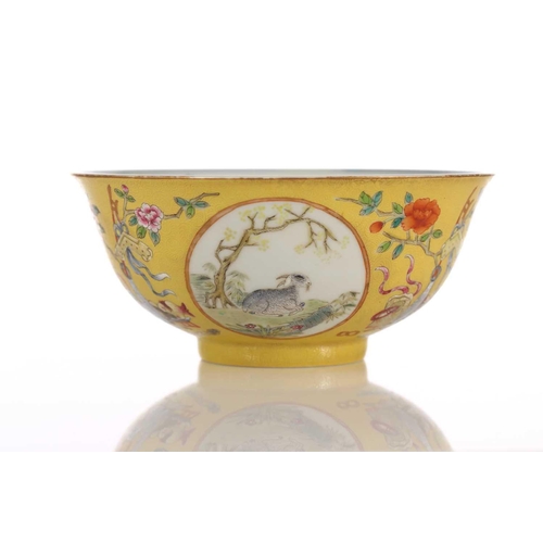 170 - A Chinese yellow ground bowl, 20th century, painted with medallions of goats by blossoming trees wit... 