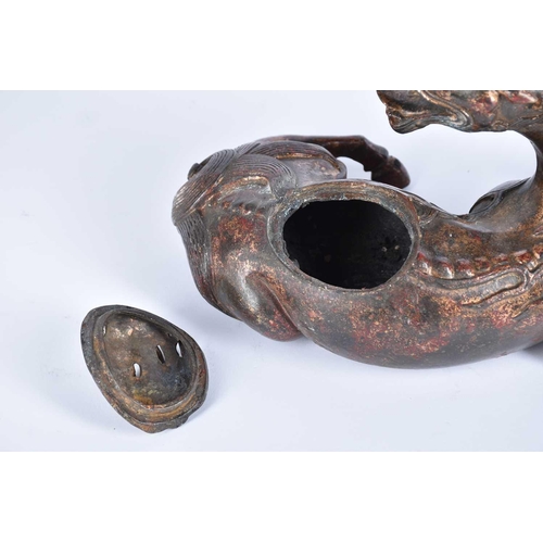 185 - A Chinese bronze censer, modelled as a Pixiu in recumbent pose, its snarling head looking over its s... 