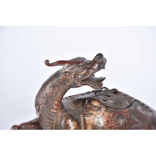 185 - A Chinese bronze censer, modelled as a Pixiu in recumbent pose, its snarling head looking over its s... 