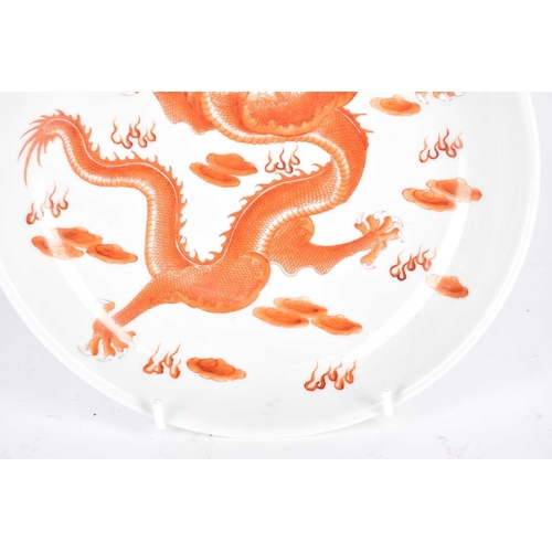 186 - A Chinese porcelain dragon dish, painted with an iron red dragon with white teeth and claws, amongst... 