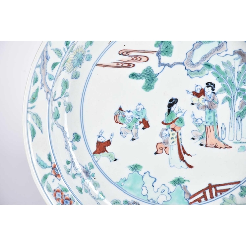 193 - A Chinese doucai basin, painted with two standing females with six boys at play, within a landscape ... 