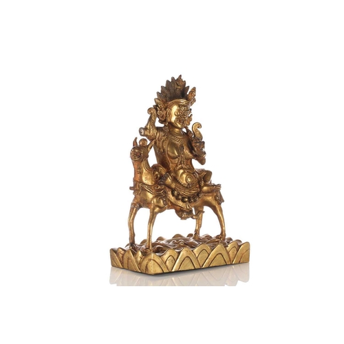 194 - A Sino-Tibetan gilt-bronze figure of Palden Lhamo riding sideways on a mule holding a kapala in her ... 