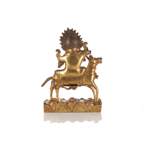 194 - A Sino-Tibetan gilt-bronze figure of Palden Lhamo riding sideways on a mule holding a kapala in her ... 