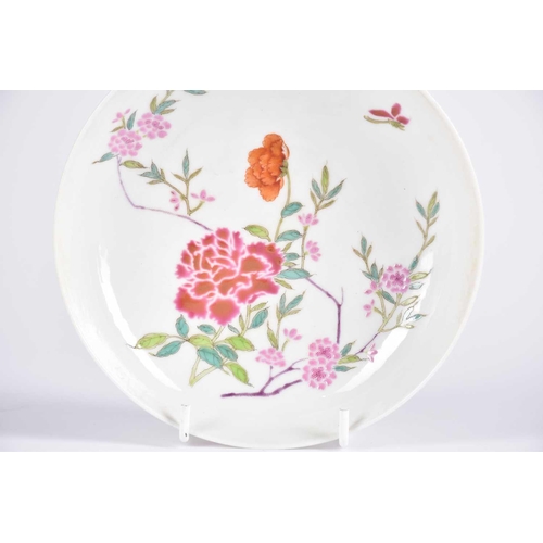 217 - A Chinese famille rose saucer dish, painted with blossoming peony, stems and leaves, with a single i... 