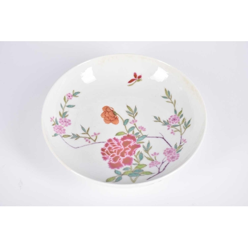 217 - A Chinese famille rose saucer dish, painted with blossoming peony, stems and leaves, with a single i... 