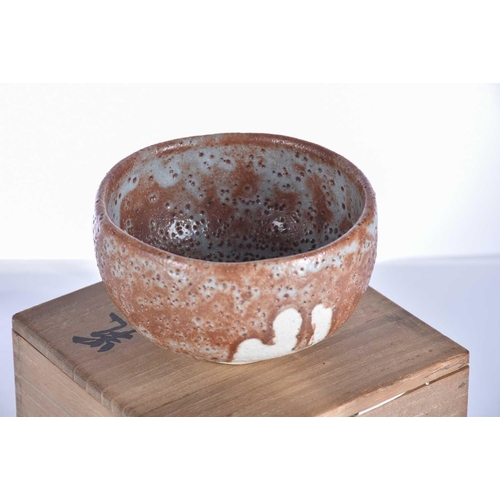 221 - A Japanese Shino Chawan, 20th century, with a pitted brown, grey and white glaze, 13cm diameter, in ... 