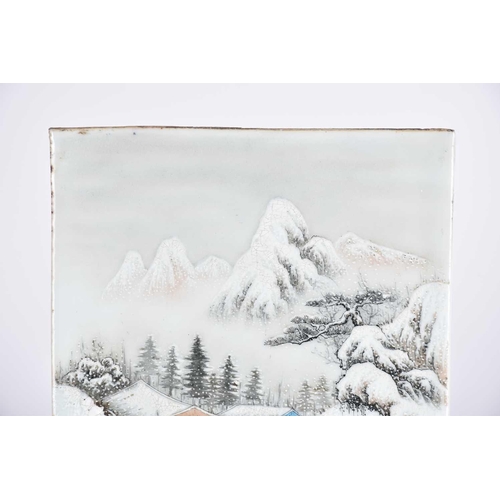 232 - A Chinese porcelain panel, 20th century, painted with a snow scene of a figure approaching a bridge ... 