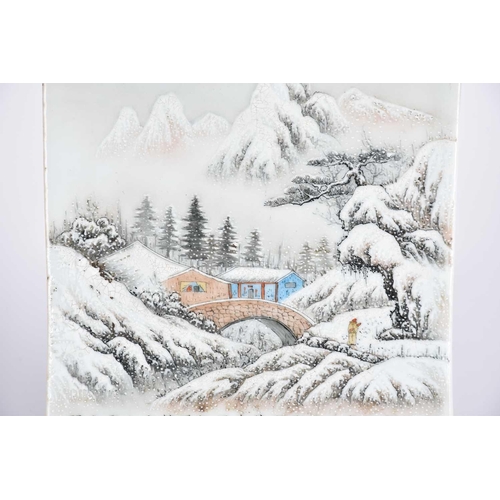 232 - A Chinese porcelain panel, 20th century, painted with a snow scene of a figure approaching a bridge ... 