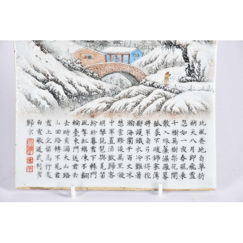 232 - A Chinese porcelain panel, 20th century, painted with a snow scene of a figure approaching a bridge ... 