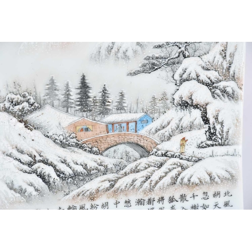 232 - A Chinese porcelain panel, 20th century, painted with a snow scene of a figure approaching a bridge ... 