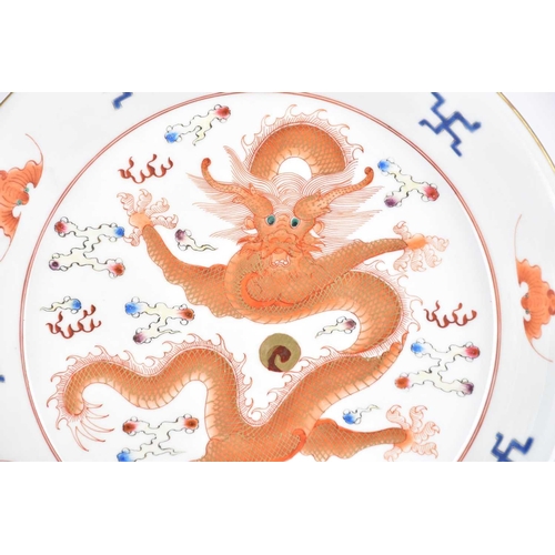 243 - A Chinese porcelain saucer plate, painted with an iron red and gilt dragon amongst clouds, the raise... 