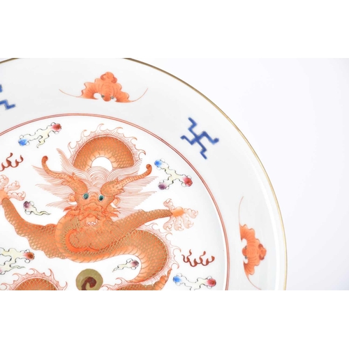 243 - A Chinese porcelain saucer plate, painted with an iron red and gilt dragon amongst clouds, the raise... 