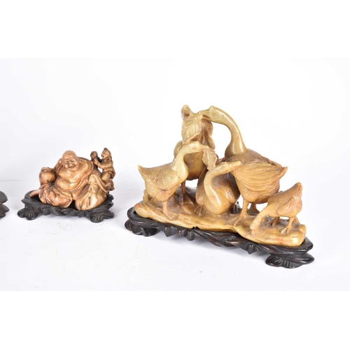 253 - Four Chinese soapstone carvings, late Qing to early 20th century, three as deities Shou Lao, Budai a... 