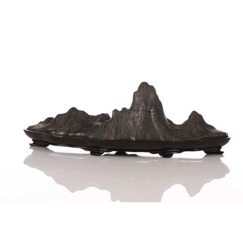 257 - A Chinese carved and part polished stone brush rest, of mountain form with six peaks, on fitted wood... 