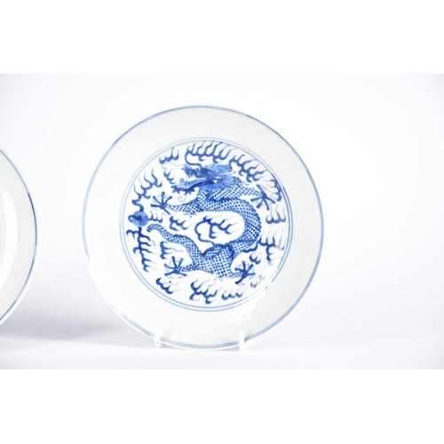 265 - A pair of Chinese blue & white porcelain dragon dishes, painted with a writhing dragon chasing a fla... 