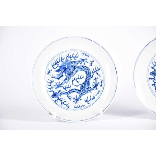 265 - A pair of Chinese blue & white porcelain dragon dishes, painted with a writhing dragon chasing a fla... 