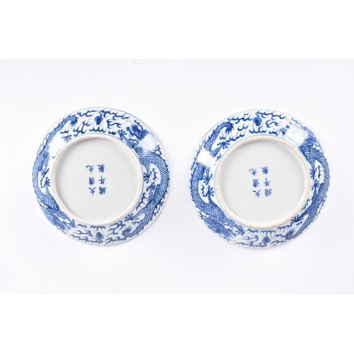 265 - A pair of Chinese blue & white porcelain dragon dishes, painted with a writhing dragon chasing a fla... 