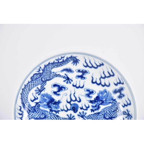 267 - A Chinese blue & white saucer dish, painted with two opposing dragons facing a flaming pearl amongst... 