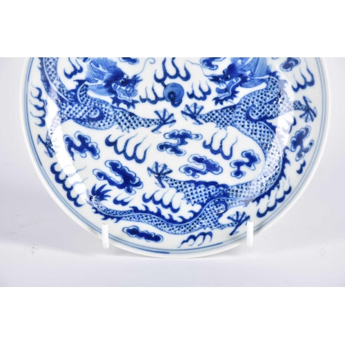 267 - A Chinese blue & white saucer dish, painted with two opposing dragons facing a flaming pearl amongst... 