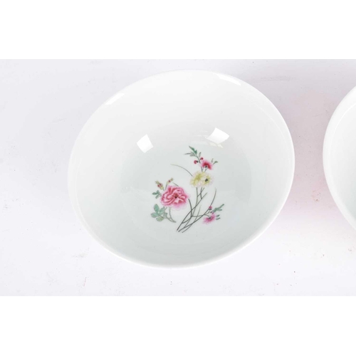 277 - A pair of Chinese famille rose bowls, the interiors painted with a sprig of peony, the exterior with... 