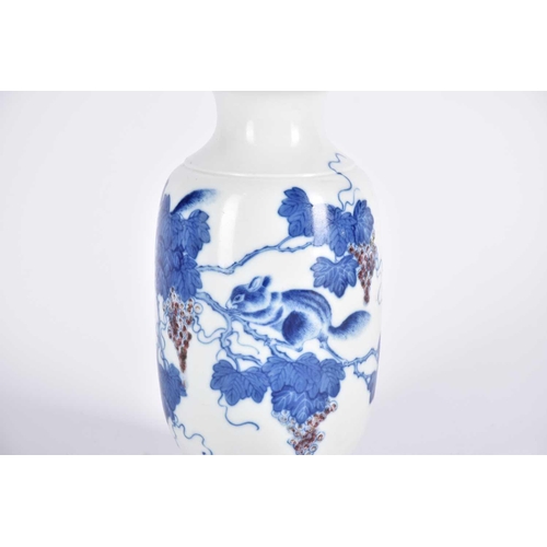 282 - A Chinese blue, white and iron red vase, painted with underglaze blue fruiting vines and a tree rat,... 