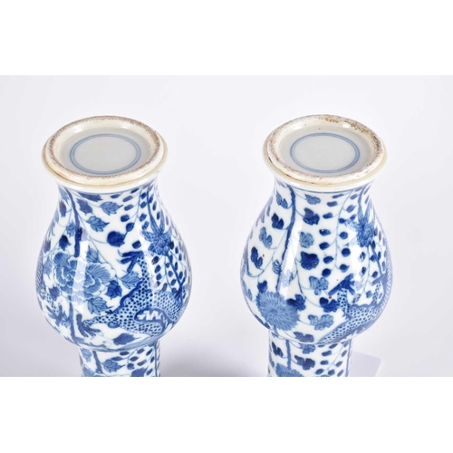 290 - A pair of Chinese blue & white fengweizun vases, painted with opposing dragons amongst lotus and tre... 