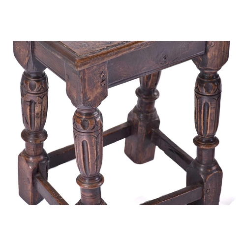 306 - A Jacobean style oak joint stool with thumb moulded top over carved, slender cup and cover spindles ... 