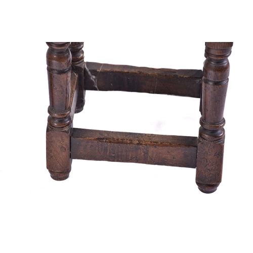 306 - A Jacobean style oak joint stool with thumb moulded top over carved, slender cup and cover spindles ... 