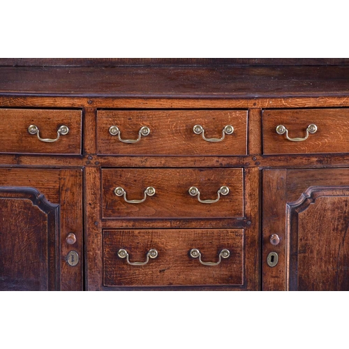 309 - A George III oak dresser and Delft rack fitted three open shelves above a base with three frieze dra... 