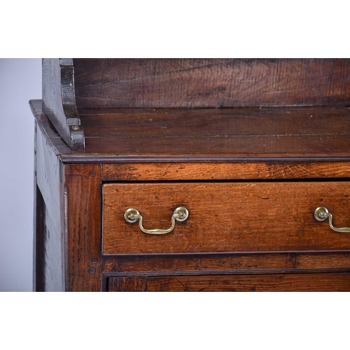 309 - A George III oak dresser and Delft rack fitted three open shelves above a base with three frieze dra... 