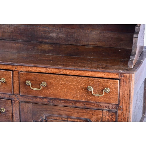 309 - A George III oak dresser and Delft rack fitted three open shelves above a base with three frieze dra... 