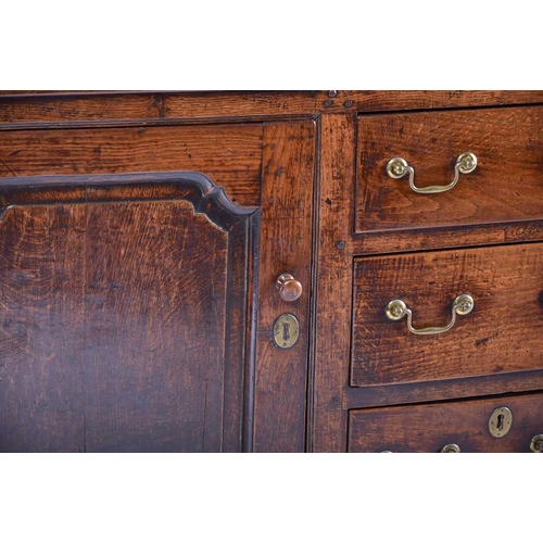 309 - A George III oak dresser and Delft rack fitted three open shelves above a base with three frieze dra... 