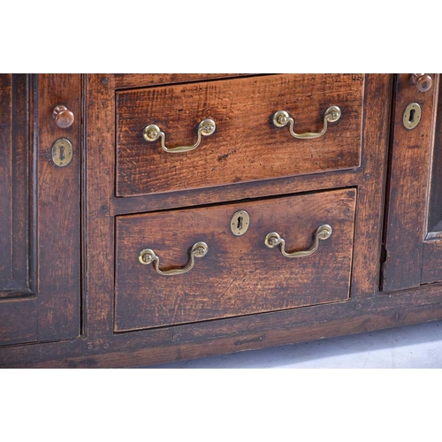 309 - A George III oak dresser and Delft rack fitted three open shelves above a base with three frieze dra... 