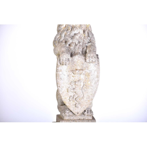 343 - A pair of cast stone figures of standing heraldic lions each holding a shield with 