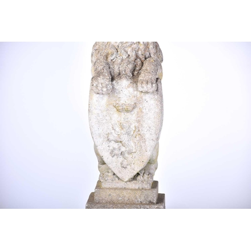 343 - A pair of cast stone figures of standing heraldic lions each holding a shield with 