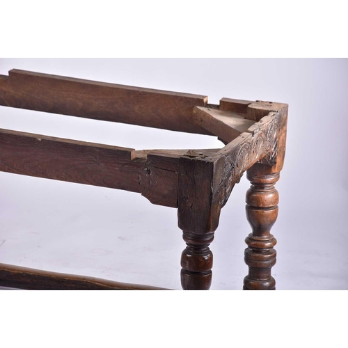 349 - A 17th century oak refectory table with clamped plank top on a box frame base with slender cup and c... 