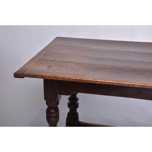 349 - A 17th century oak refectory table with clamped plank top on a box frame base with slender cup and c... 