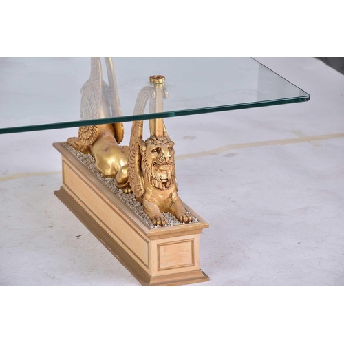 350 - An 'Egyptian Retour' glass-topped rectangular coffee table, 20th century, on gilt composition sphinx... 