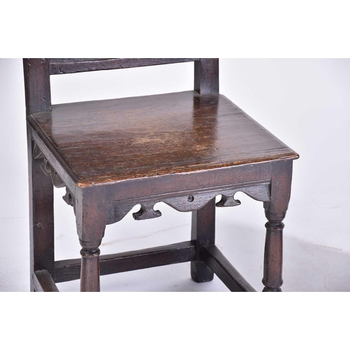 362 - A 17th-century style oak back stool with carved decoration and a solid seat above a shaped frieze. S... 