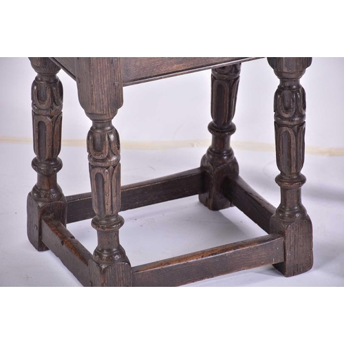 371 - A Jacobean style oak joint stool with thumb moulded top over carved, slender cup and cover spindles ... 