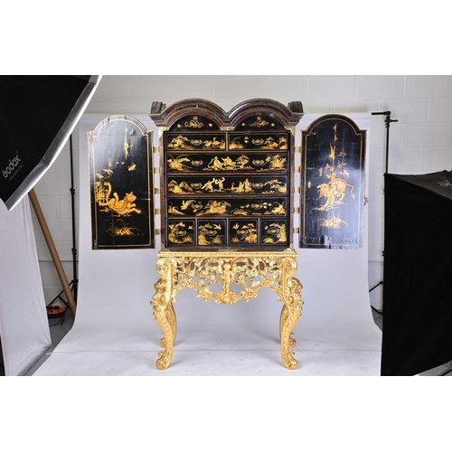 375 - A Queen Anne black lacquer double dome cabinet on a gilt stand. The upper section is decorated throu... 