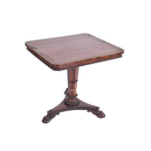 384 - A William IV rosewood and brass inlaid table, of rectangular form upon a tripartite base, with lions... 