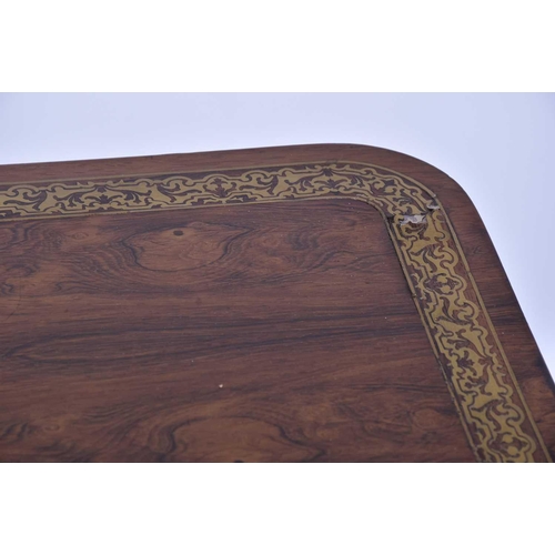 384 - A William IV rosewood and brass inlaid table, of rectangular form upon a tripartite base, with lions... 