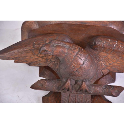 386 - A 19th-century naive carved oak wall bracket in the form of a perched spread eagle. 46 cm wide x 42 ... 