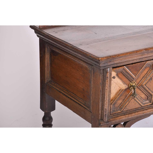 395 - A Charles II three drawer oak dresser base. Fitted three geometrically moulded deep drawers, on turn... 