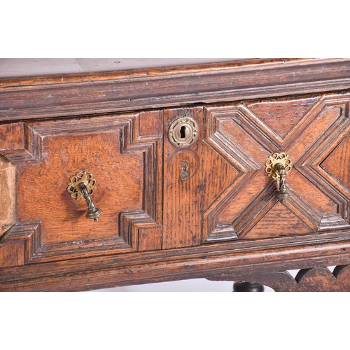 395 - A Charles II three drawer oak dresser base. Fitted three geometrically moulded deep drawers, on turn... 