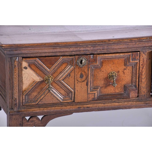 395 - A Charles II three drawer oak dresser base. Fitted three geometrically moulded deep drawers, on turn... 