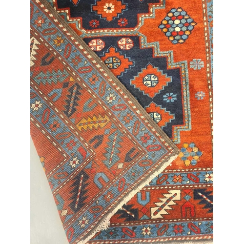 402 - A brick red ground Kashan rug, 20th century, with three stepped lozenges within a serrated leaf and ... 