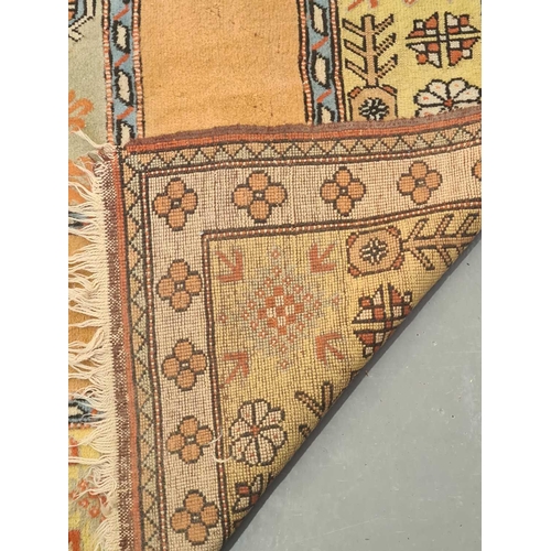 404 - A peach ground Turkish Milas carpet, 20th century, with a central blue rectangle and geometric decor... 